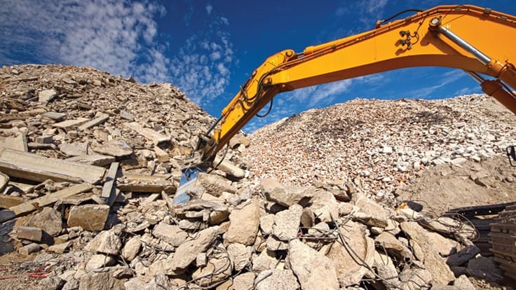 an excavator working in a construction and demolition landfill