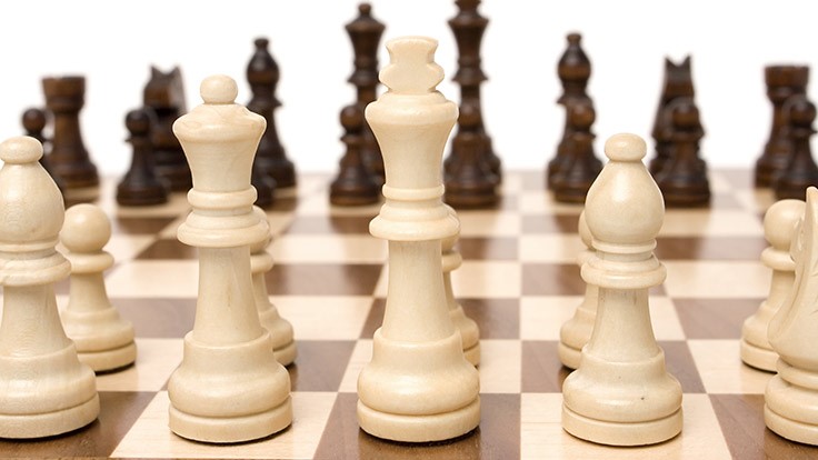Chess pieces facing one another on a game board