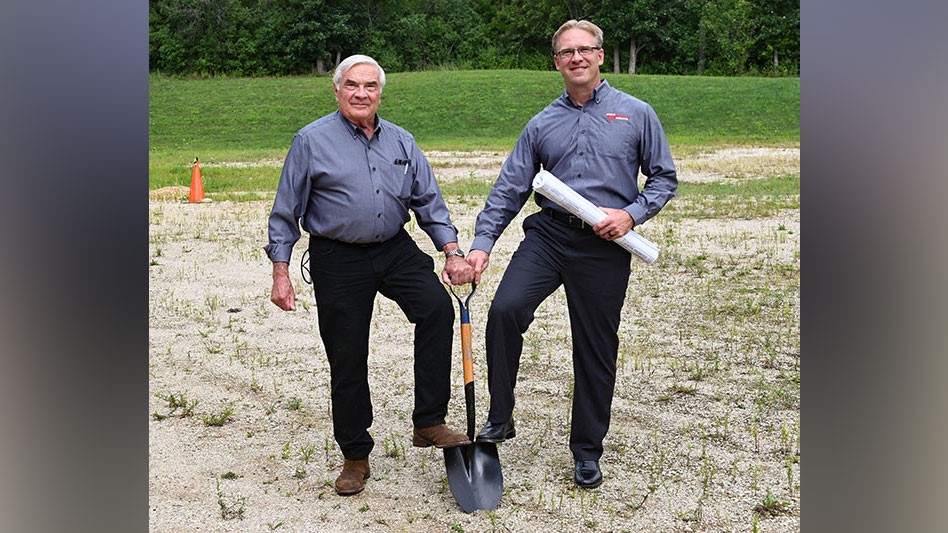 an older man and a younger man holding a shovel