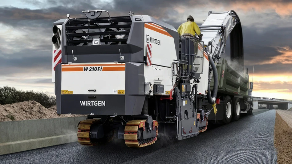 Wirtgen equipment at work on a road against a backdrop of a sunset