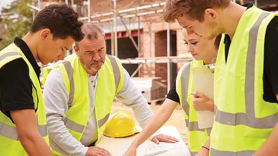 Several construction workers look over plans