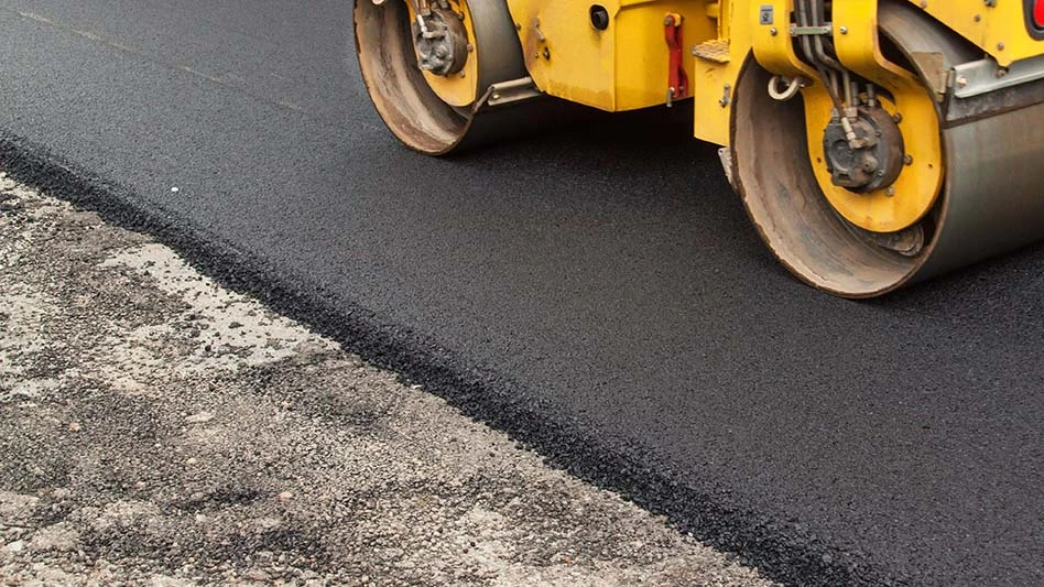 fresh asphalt with a roller going over it