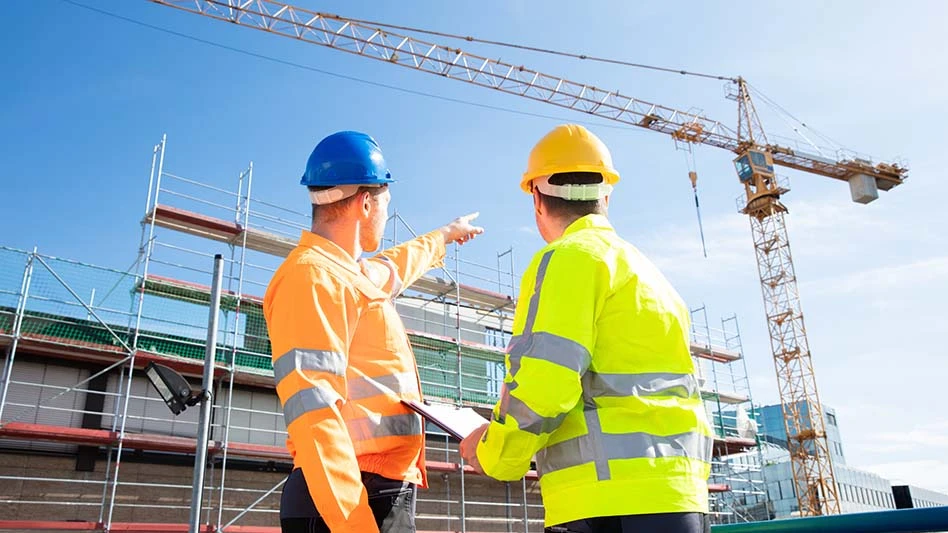 workers in hardhats looking at crane