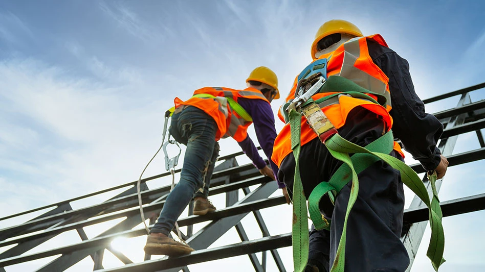 construction workers climbing frame with body harnesses