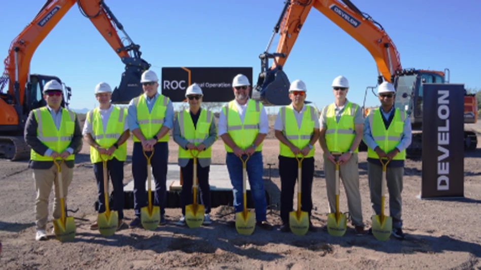 Construction workers stand outside new facility.
