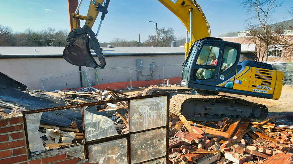 excavator amid brick, construction and demolition debris