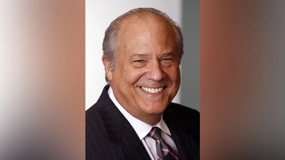 a smiling man in a suit and tie with balding gray hair